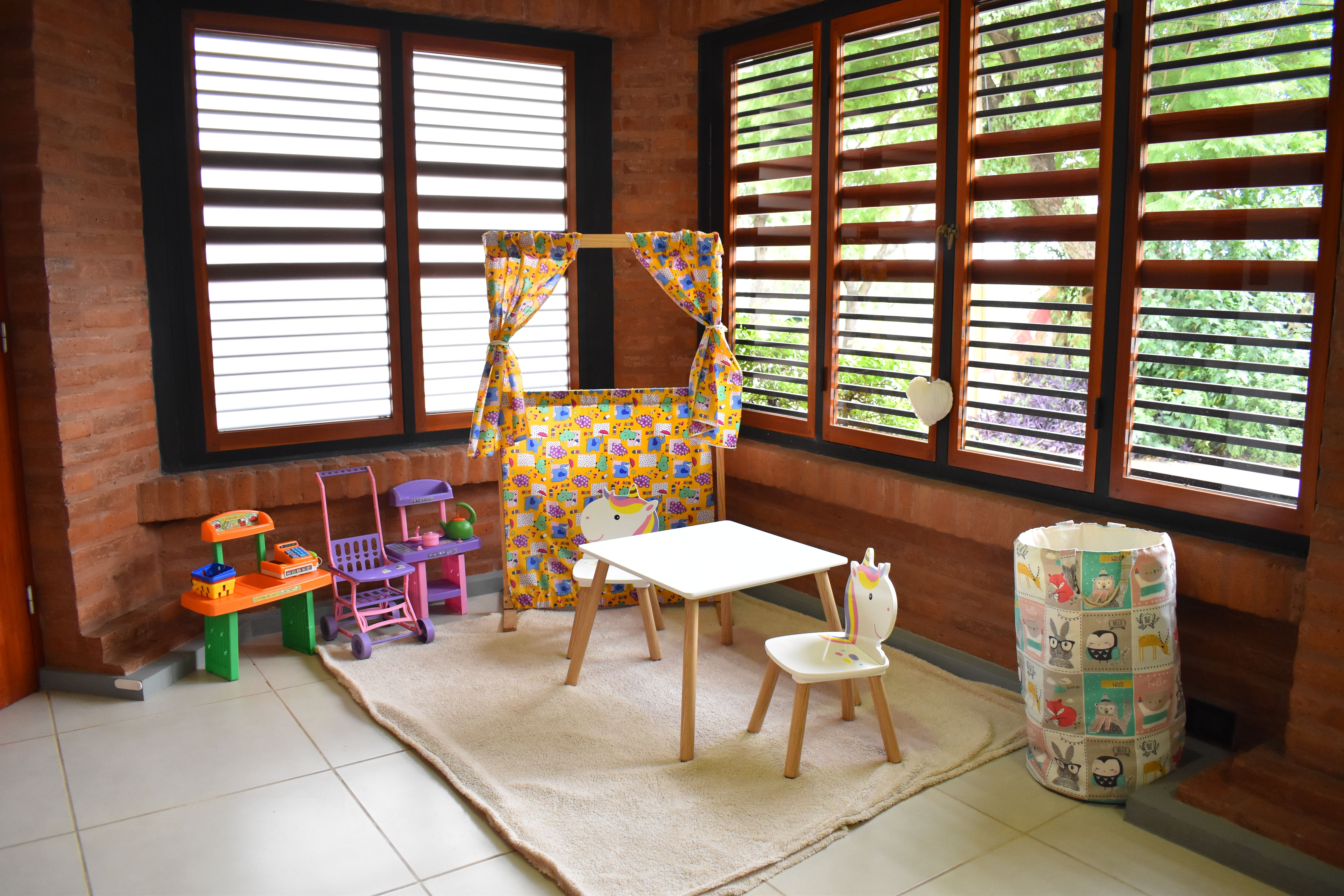 Rincón infantil de Casa Amatista con teatro de marionetas y mesa de juegos
